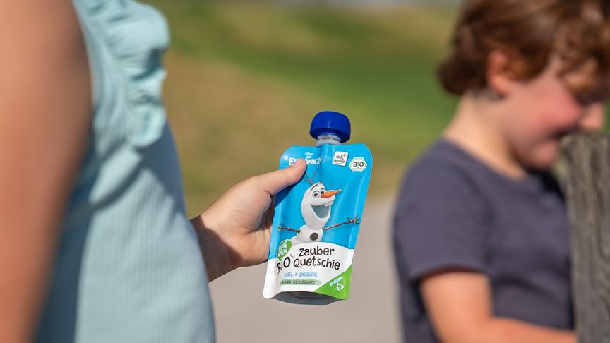 Ein Mädchen hält ein Quetschie von PURE&FUN mit "Olaf"-Aufdruck in der Hand.