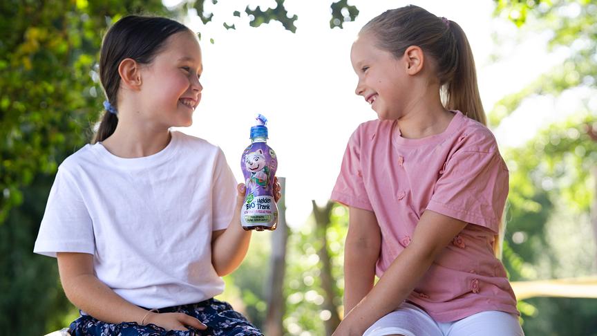 Zwei Mädchen teilen sich ein Getränk von PURE&FUN.