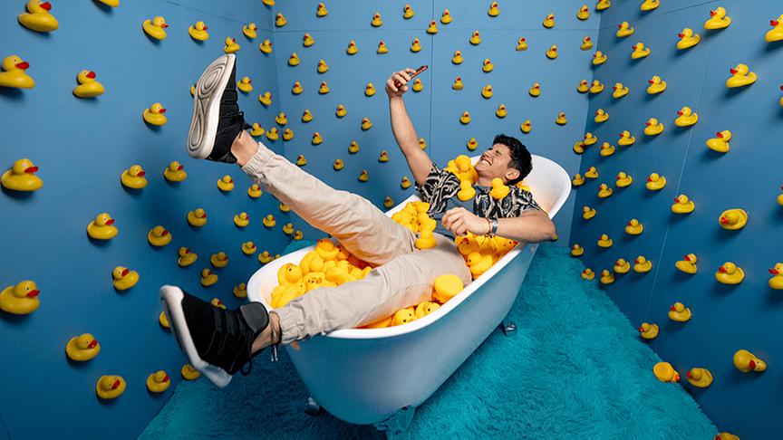 © Foto: Bubble Planet Fotospot mit jungen Mann in Badewanne voll mit Quietscheenten