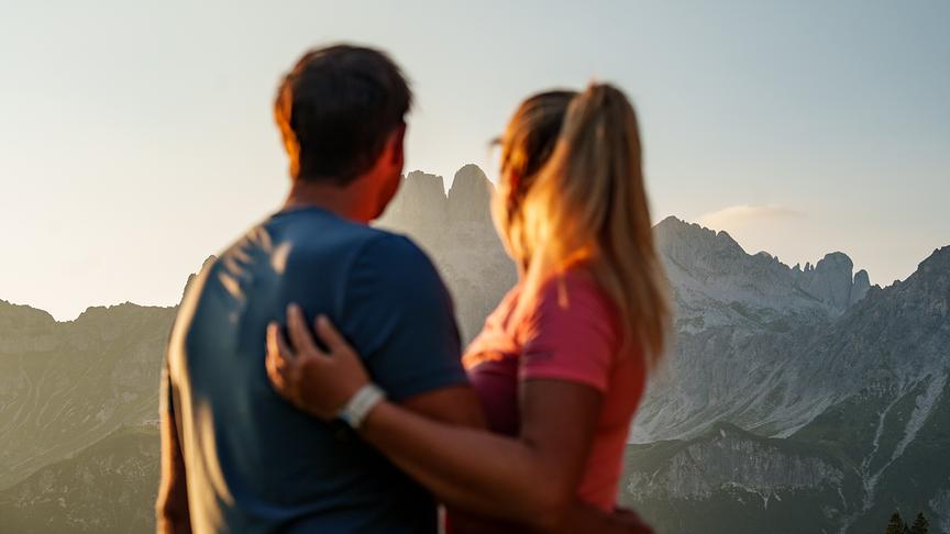 Ein Pärchen blickt auf eine Bergkulisse