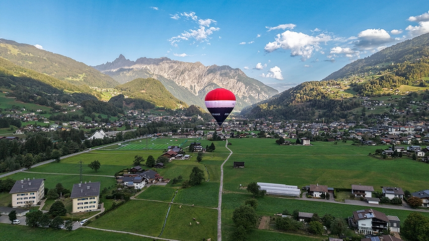 Ein REMAX-Ballon schwebt über der Landschaft.