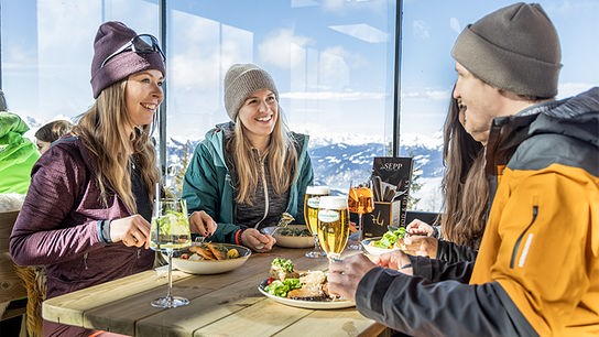 Vier Skifahrer stärken sich beim Hütten-Essen