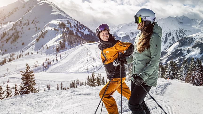 Ein Pärchen freut sich aufs Skifahren auf der Piste.