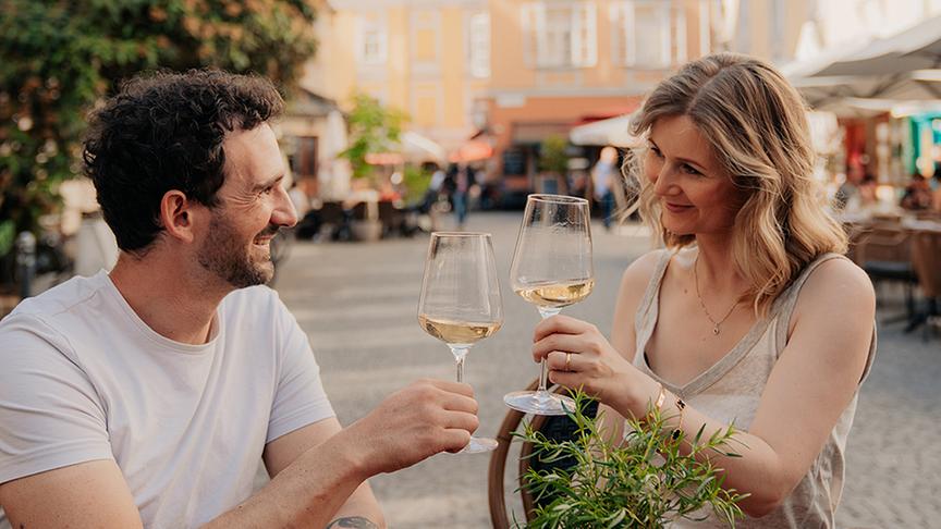 Ein Pärchen sitzt in einem Gastgarten in Graz