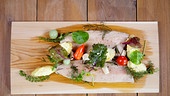 Forellenfilet, gegrillt auf Zedernbrett, mit Wildkräutersalat und gefüllten Heurigen