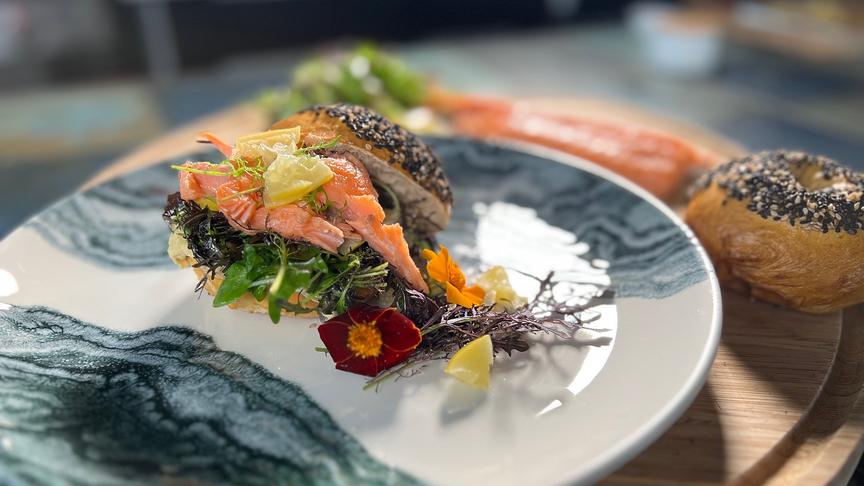 Bagel mit gezupftem Seesaibling, Salzzitronen und Wildkräutersalat