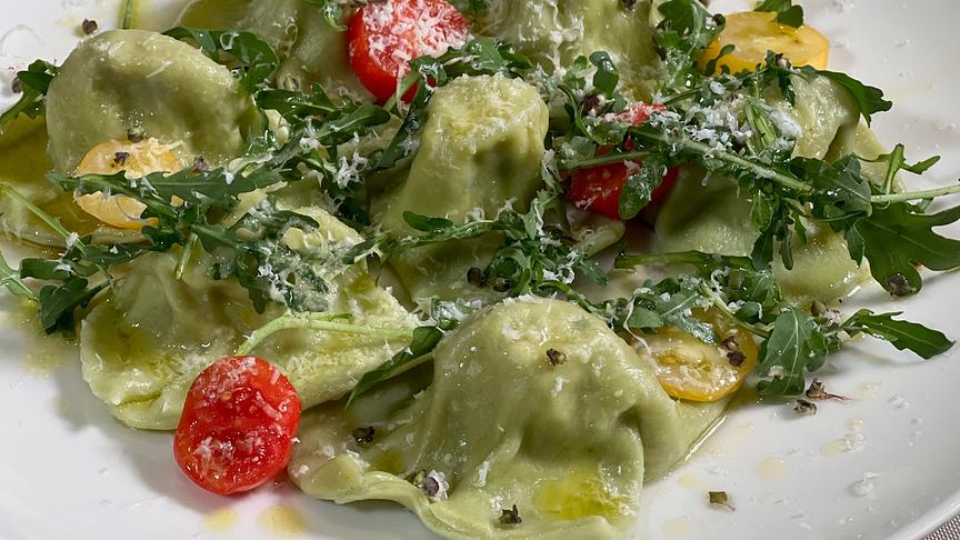 Basilikumravioli mit brauner Butter, Tomaten, Rucola und Parmesan