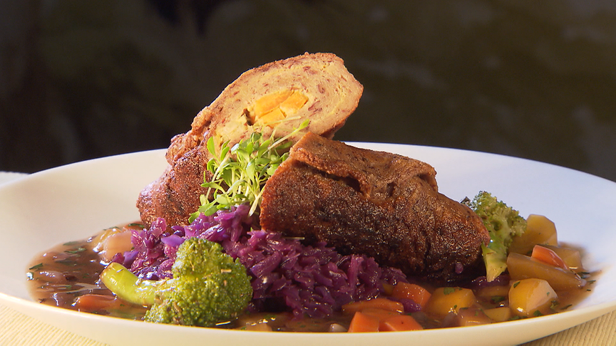Kross gebratene vegane Seitan-Rouladen mit würziger Gemüsefüllung, serviert mit dunkler Bratensauce aus Wurzelgemüse.