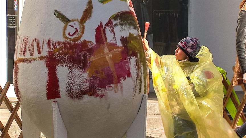 Im Bild: Kinder bemalen große Ostereier am Markt in Schwaz.