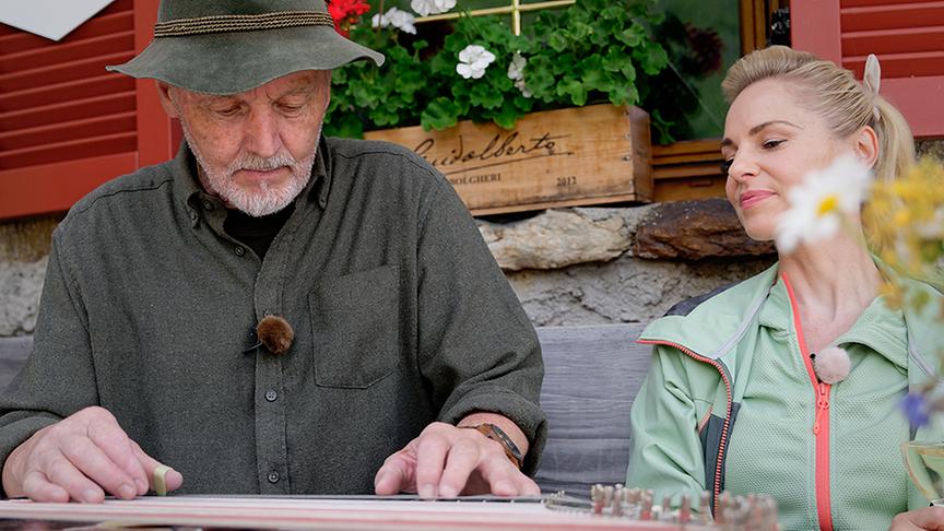 Gottlied Jehle spielt Zither bei einer Hütte auf der Larein Alpe.