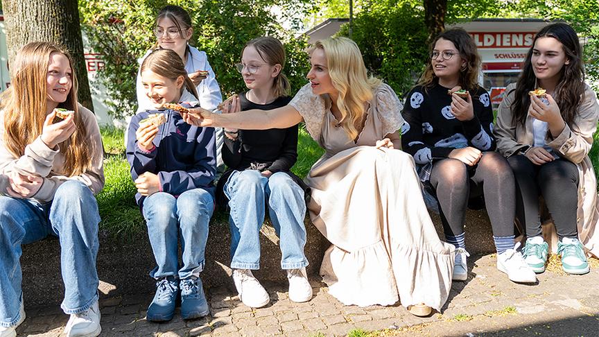 © ORF/ Silvia Schneider GmbH/ Dominik Grüner Silvia streicht mit Schülerinnen Jausenbrote.