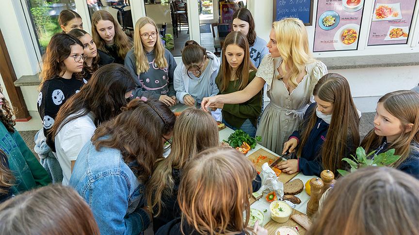 © ORF/ Silvia Schneider GmbH/ Dominik Grüner Silvia streicht mit Schülerinnen Jausenbrote.