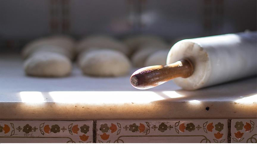 © Unsplash (Beispielfoto) Teigrolle mit Buchteln im Hintergrund