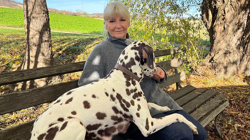 Margot Nemecek sitzt mit einem Dalmatiner auf einer Bank