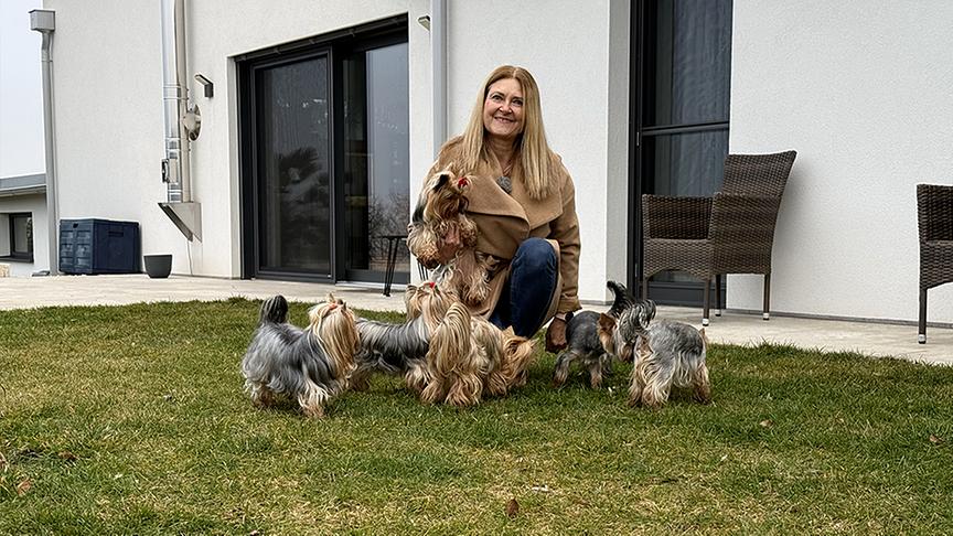 Marika Barth spielt mit Yorkshire-Terrier im Garten.