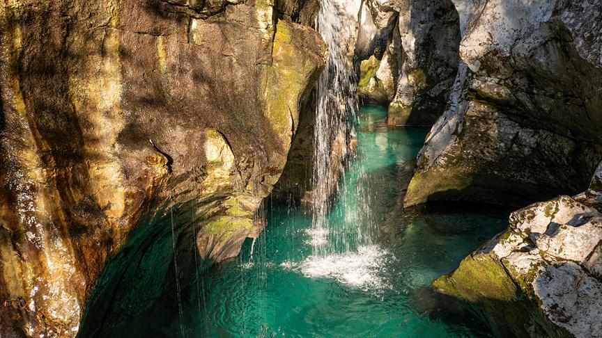 Türkiser Wasserlauf, der sich durch interessante Steinsformationen windet.