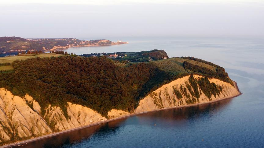 Steil abfallende, helle Küstenlinie.