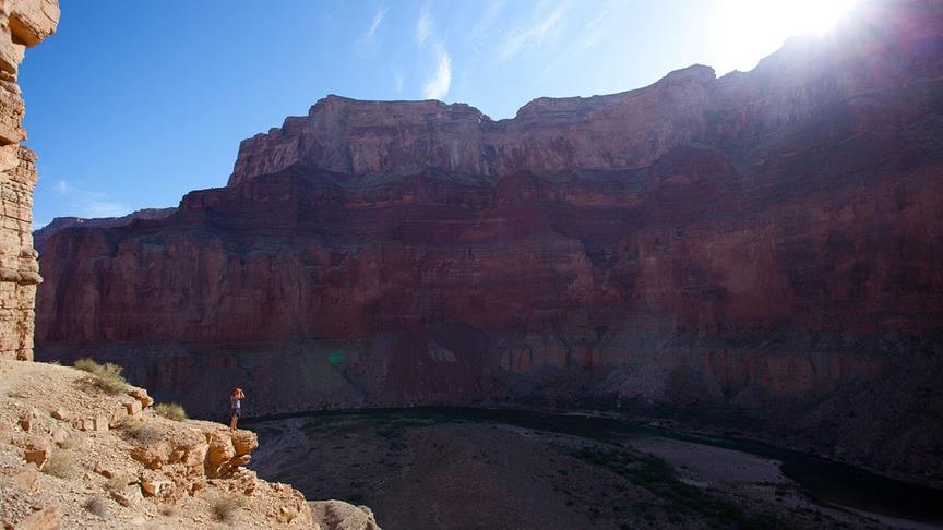 Innenansicht des Canyons - eine Person, die auf einem Felsen steht lässt die Größe des Canyon erahnen.