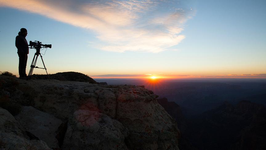 Silhouette eines Kameramanns vor einem Sonnenuntergang.