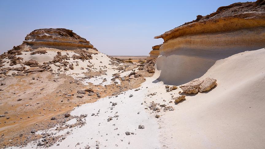 Felsformationen an die sich Sanddünen gelegt haben