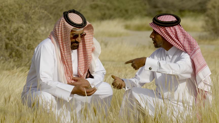 Zwei Männer mit langem Gewand und Kopftuch im Gespräch miteinander