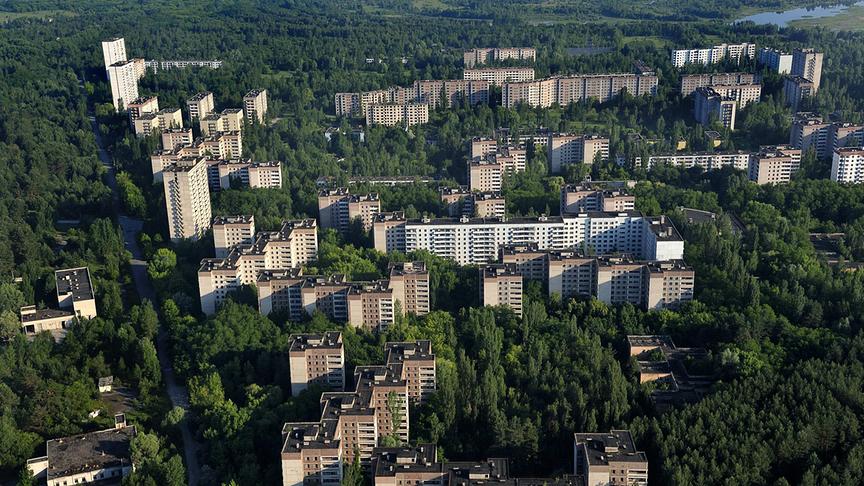 Mehrere Wohnkomplexe ragen auf einer bewaldeten Umgebung empor