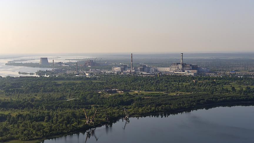 Reaktorgebäude umgeben von bewaldeter Fläche und Wasserläufen