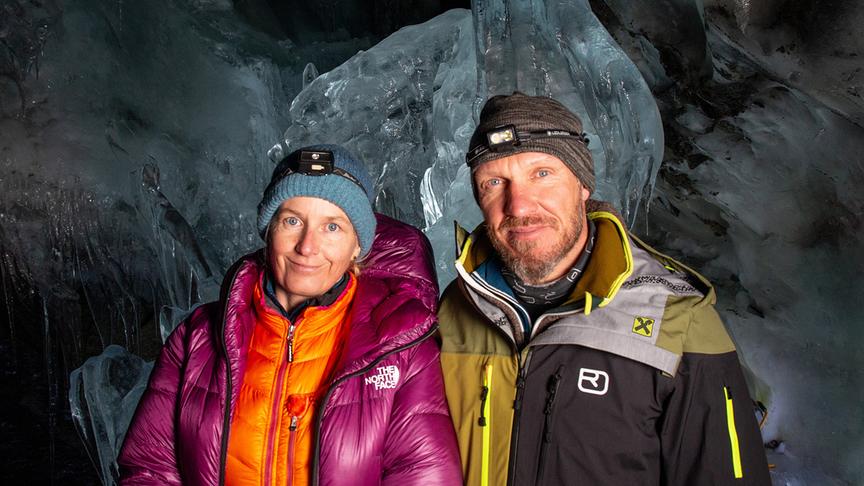 Andrea Fischer und Hermann Maier warm bekleidet und mit Stirnlampen in einer dunklen Gletscherhöhle.