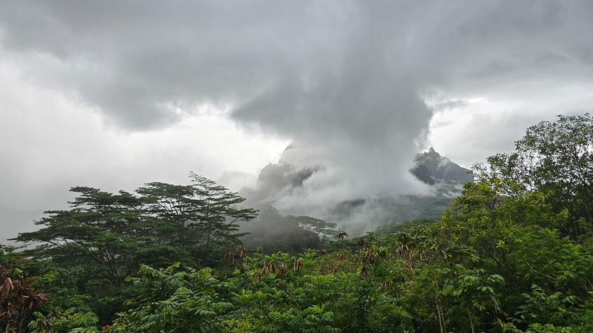 Graue Regenwolken verschleiern die Landschaft und Berge der grünen Insel.