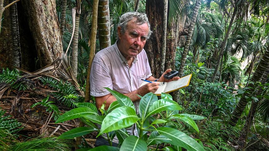 Man steht im Wald und dokumentiert in einem Notizheft