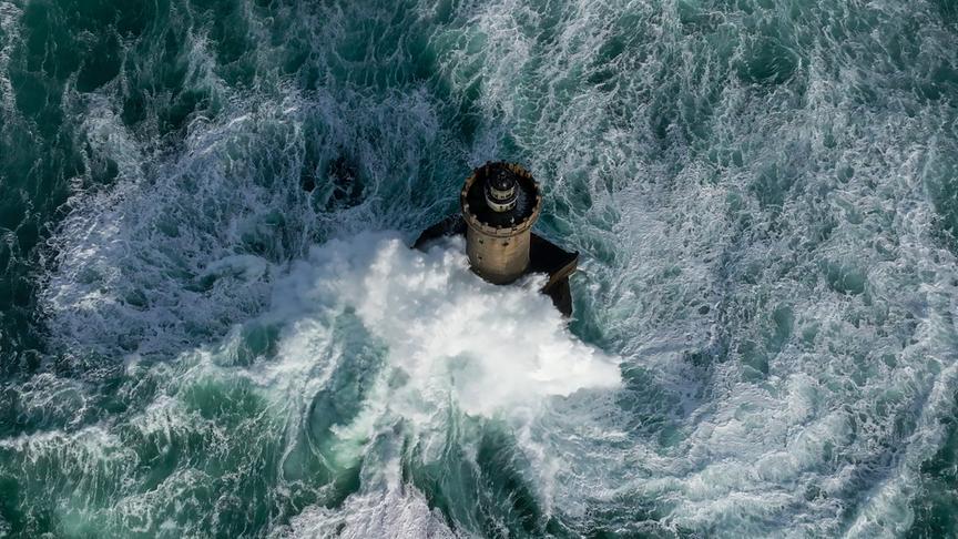 Im Bild: Wo das Meer auf Land trifft, entfesselt es seine Kraft – Wellen krachen mit wilder Schönheit gegen die Felsen.