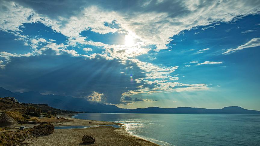 © Foto: ORF/Marco Polo Film AG/Klaus Scheurich Strand und Meer mit Bergen im Hintergrund und durch die Wolken scheinende Sonne.