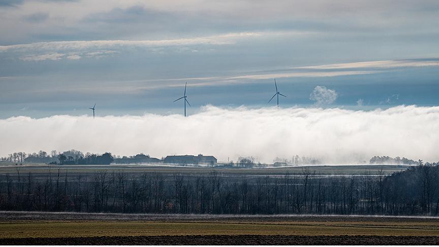 Hinter der Nebeldecke ragen die Spitzen der Windräder empor