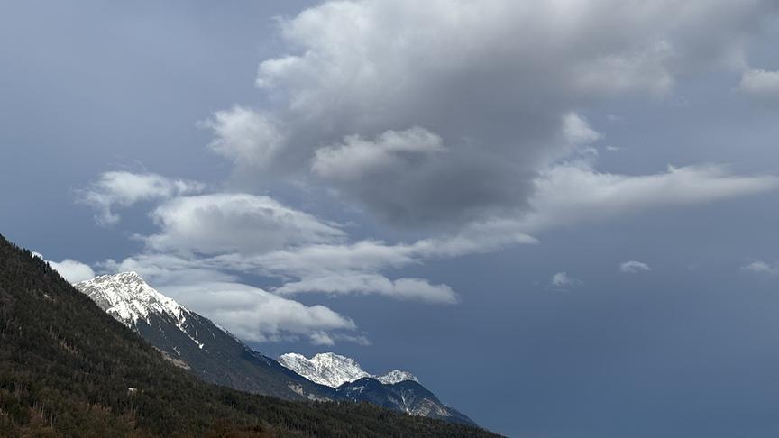 Graue Wolken über den schneebedeckten Gipfeln bei düsterer Stimmung