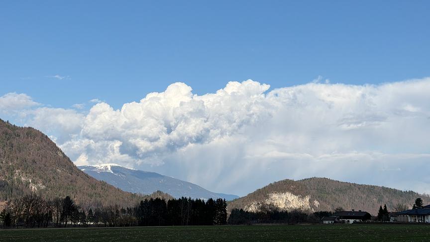 Hügellandschaft mit Sonne, im Hintergrund eine interessante Wolkenformation