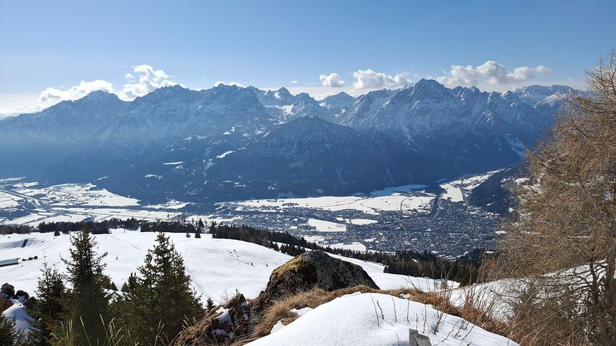 Schneebedecktes Tal mit schroffen Bergen im Hintergrund