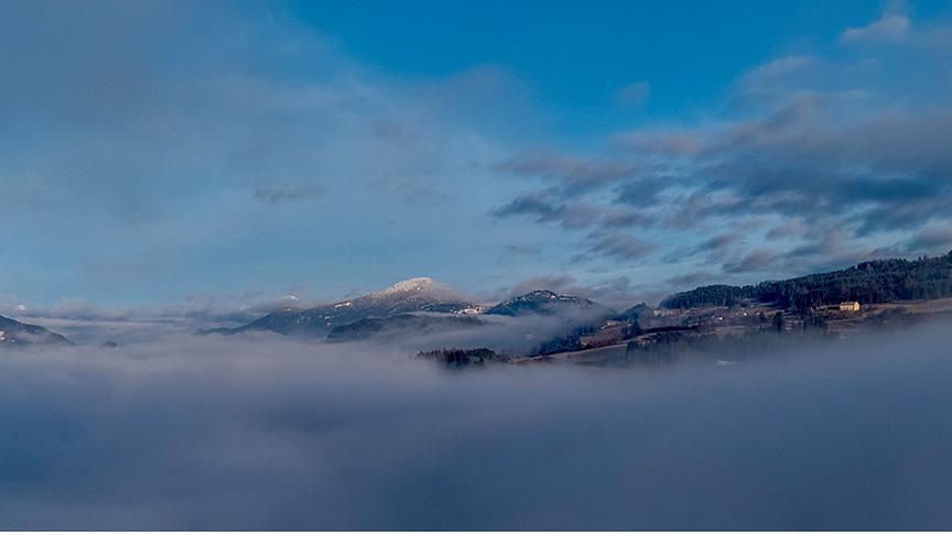 Über Nebel und Wolken strahlt ein blauer Himmel.