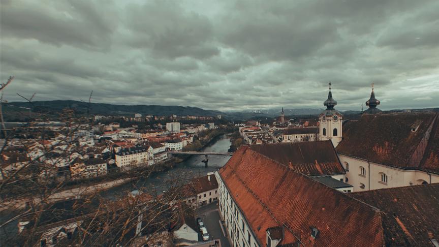 Dunkle Wolkendecke über einer Stadt mit Fluss