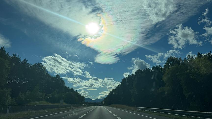 Regenbogenwolke über einer Straße