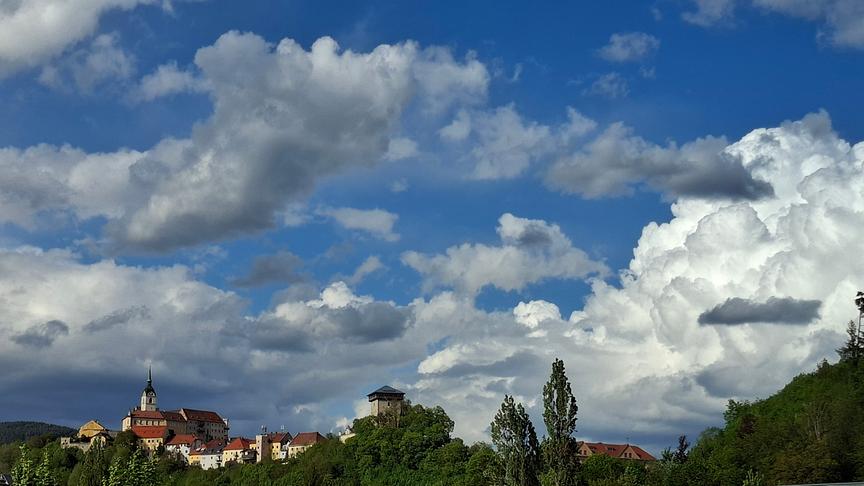 Hohe Wolkenformationen über einem Ort und Bäumen.