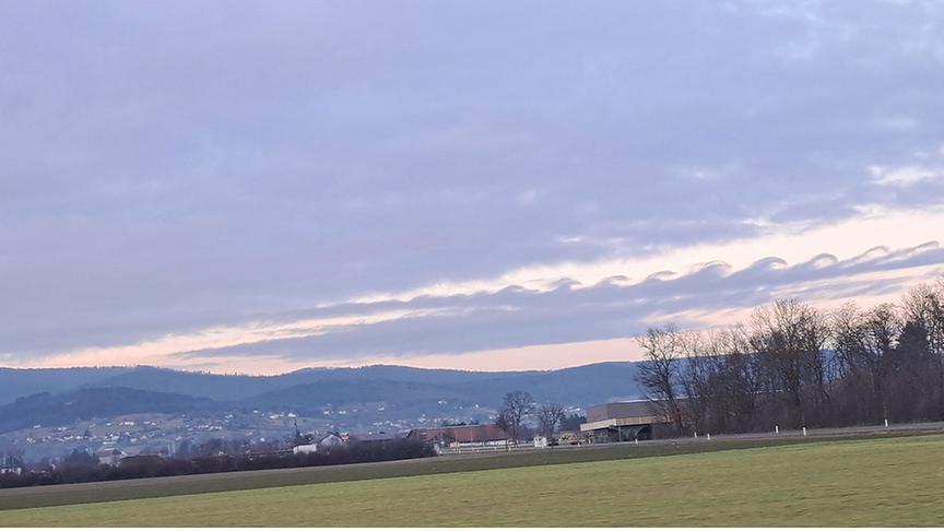 Am Horizont zieht sich eine Wolke mit mehreren Zacken ab, die aussiehen, wie Wellen.