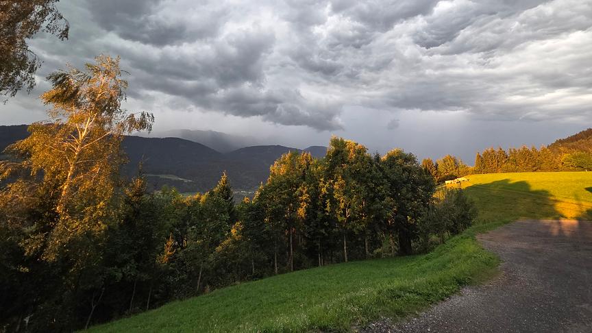 Gewitterstimmung mit Wolkendecke über einer bergigen Landschaft.