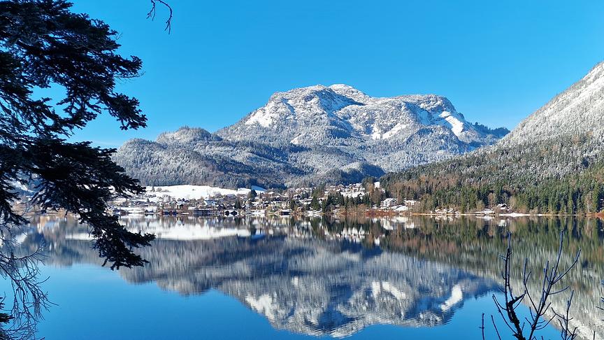 © Walter Huber Ruhiger See, indem sich die schneebedeckten Berge aus dem Hintergrund spiegeln.