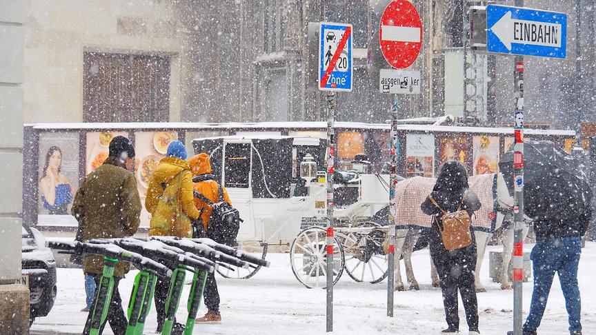Starker Schneefall am Stephansplatz bestäubt Menschen, Fiaker und E-Scooter.