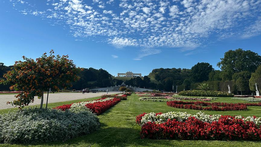 Schönbrunner Schloßpark mit Blick auf die Gloriette unter Schäfchenwolken.