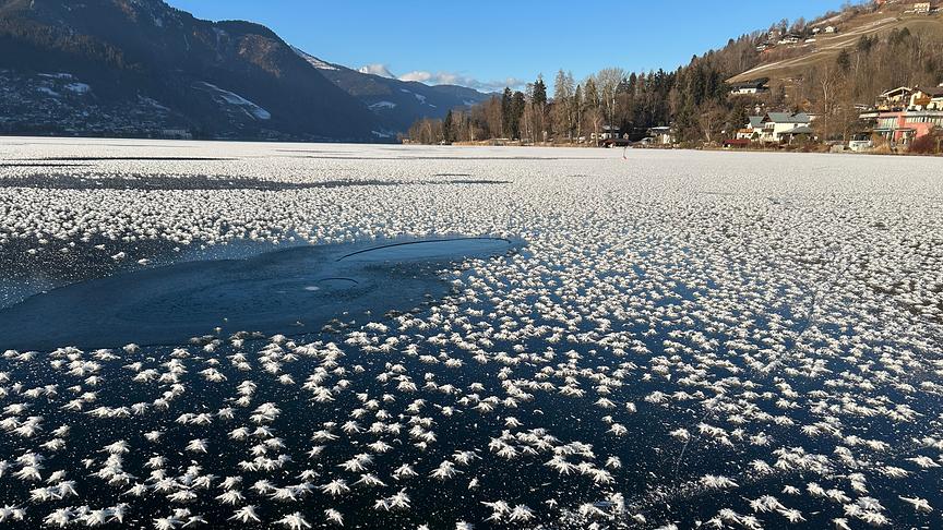 Viele, kleine einzelne Eisblumen schmücken die zugefrorene Oberfläche einen Sees