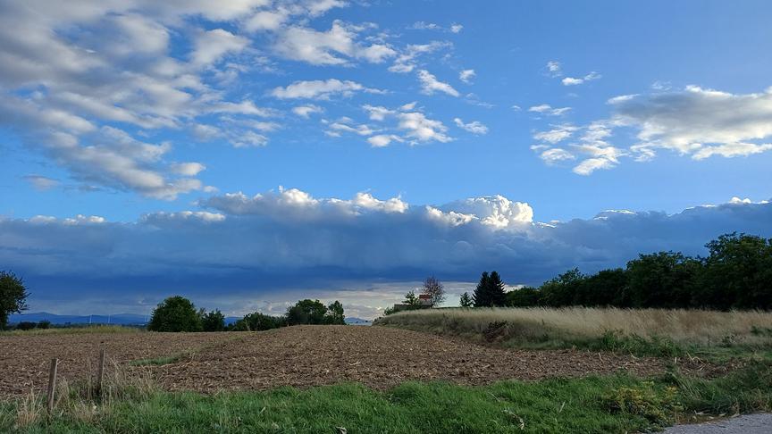 Wolkenformation über Feldern und Bäumen