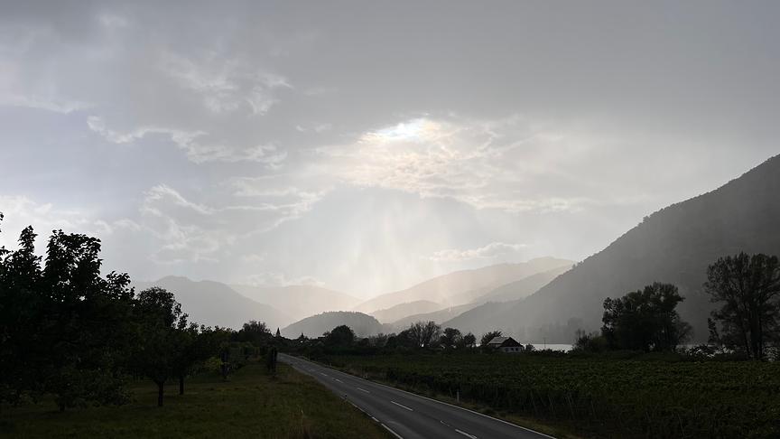 Aufbrechende dichte Wolkendecke über Bergen.