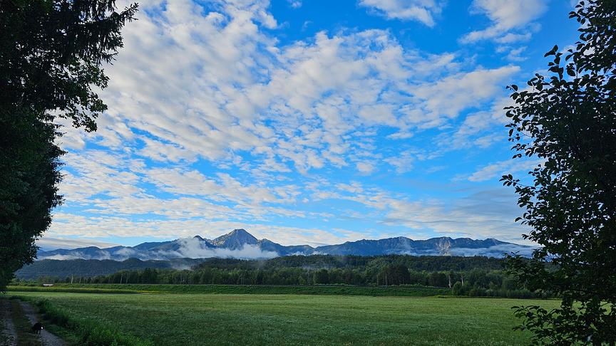 Schäfchenwolken über Bergkette.