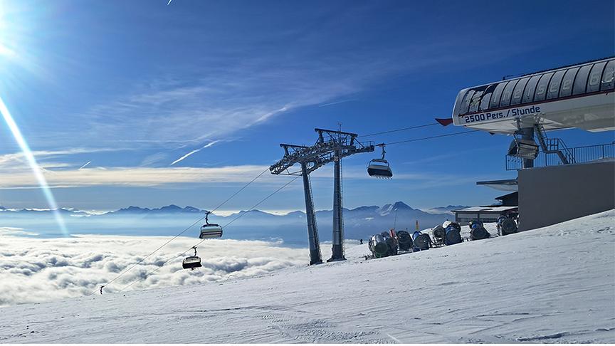 Auf der Skipiste scheint die Sonne, im Tal hängen noch Wolken